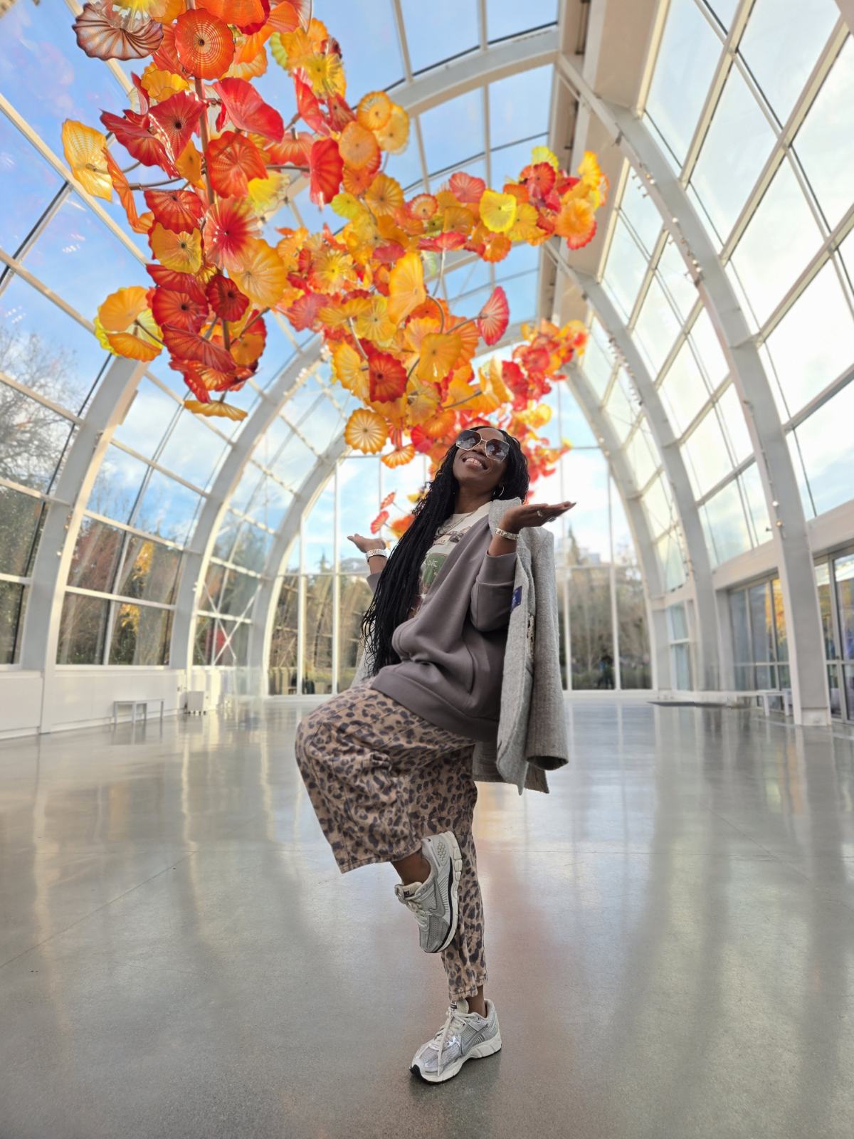 Danika smiling under the colorful glass flowers in Seattle